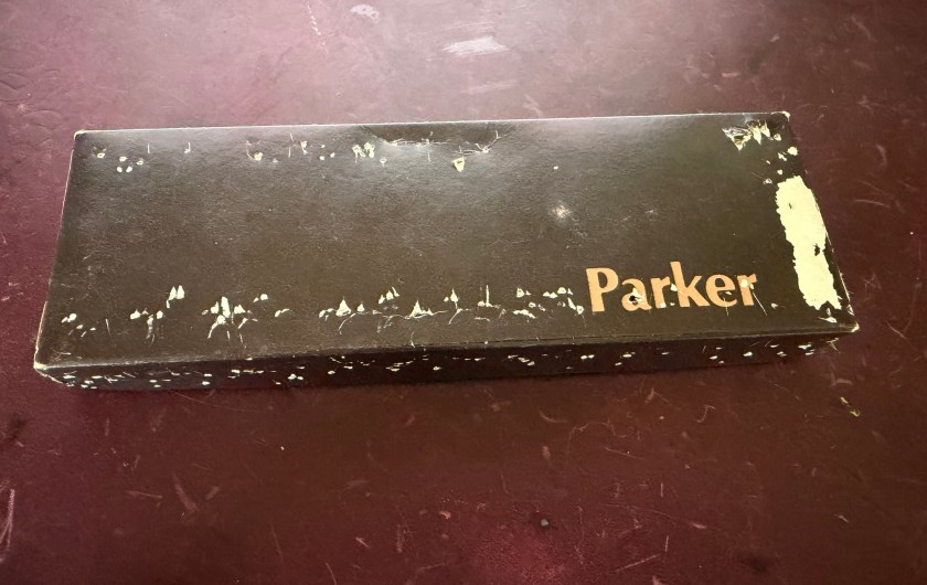 A brown box with the word Parker in the right bottom corner in a pale cream color.